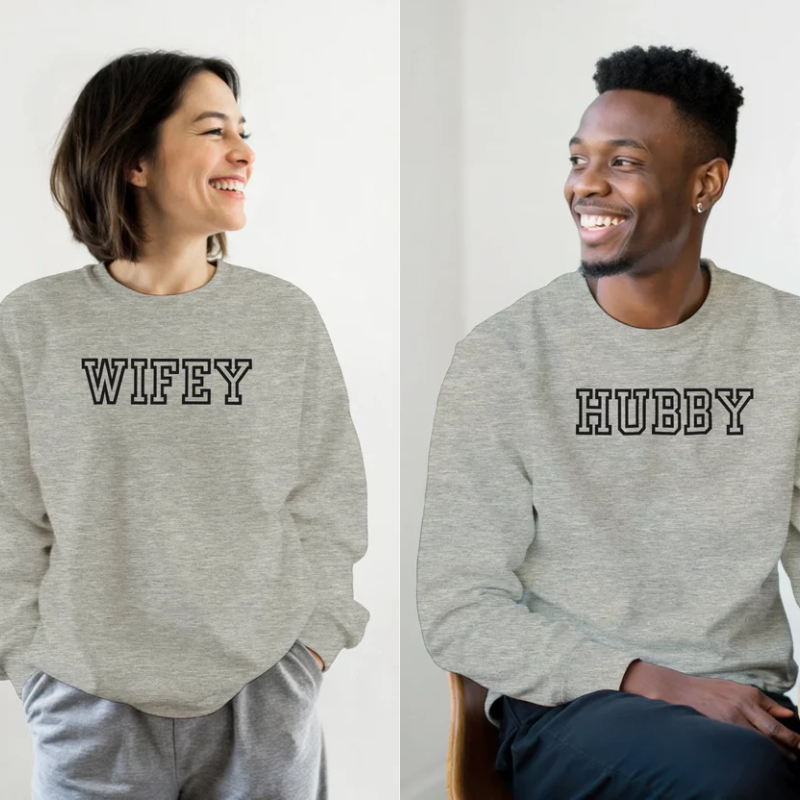 Two people wearing gray sweatshirts with 'Wifey' and 'Hubby' text.